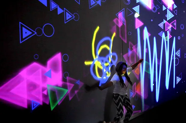 A woman dancing in front of projections.