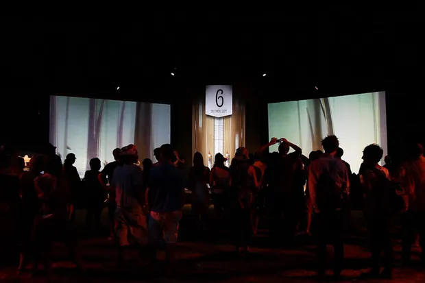 A crowd in front of the biking game screens.